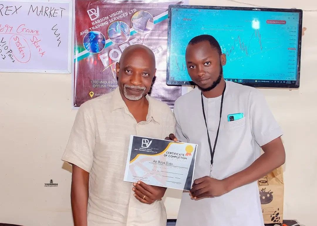 Babson presenting a certificate of completion to a graduate, Azi Bulus Dusu